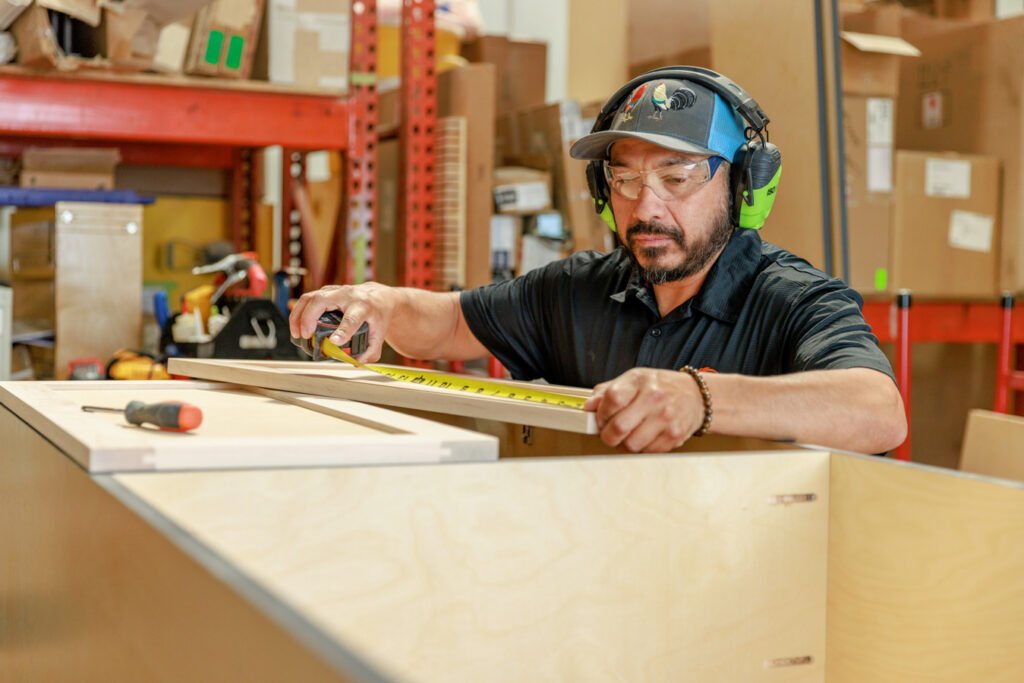 Person measuring wood in workshop