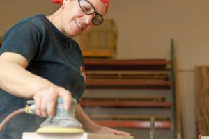 Person using a power sander.